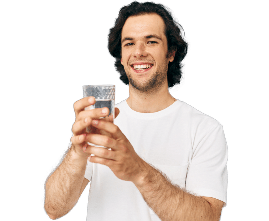 man holding a glass of water and smiling