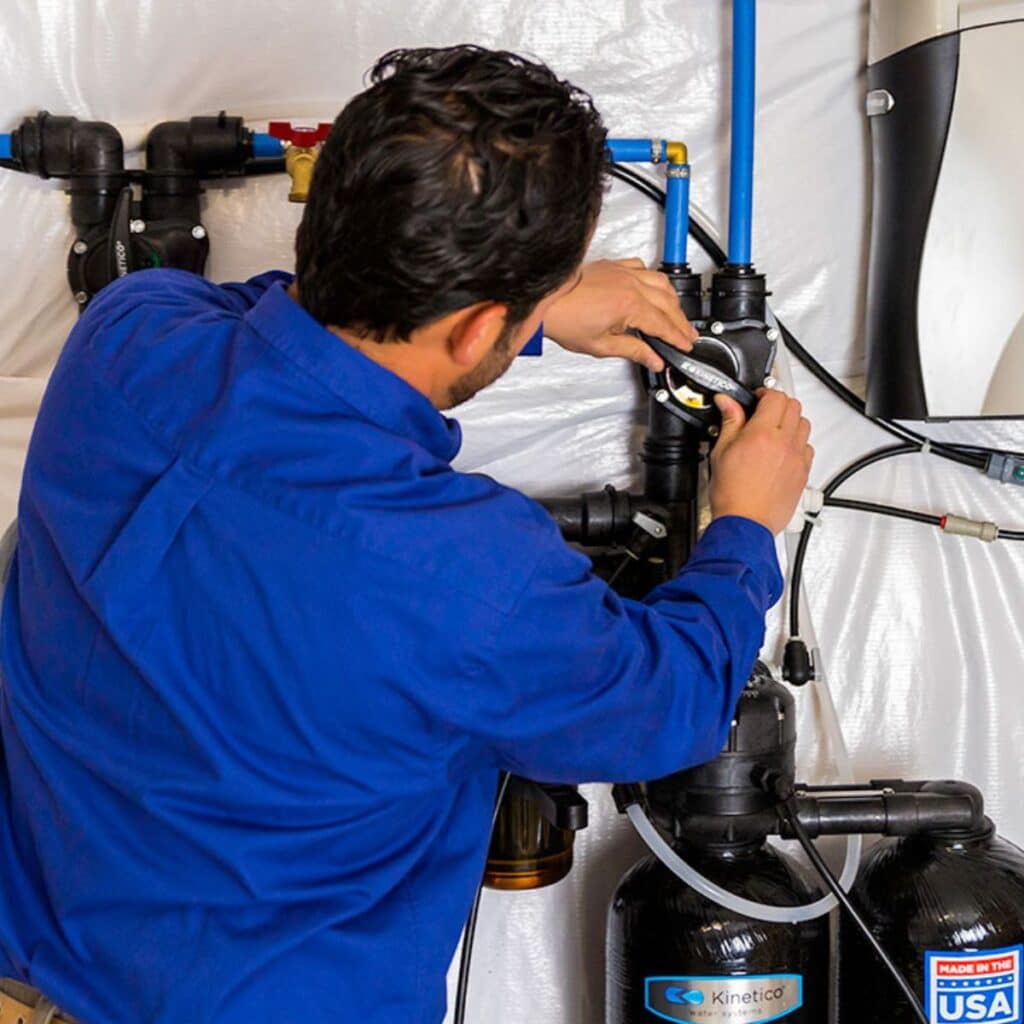 technician installing kinetico water conditioning systems
