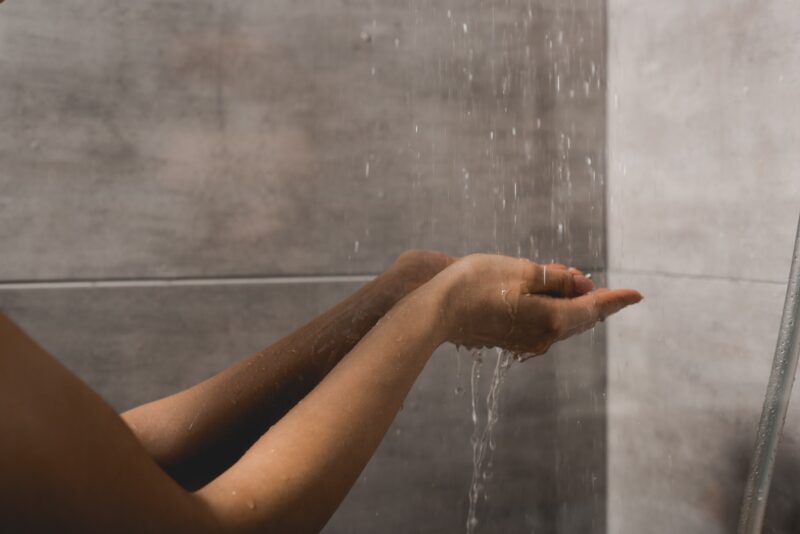 person in the shower feeling the affects of soft water
