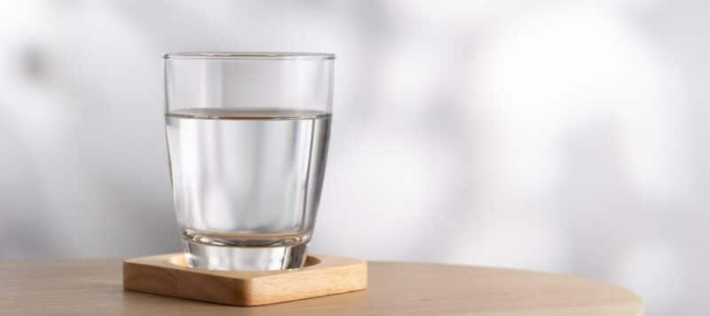 glass of water sitting on a wooden coaster
